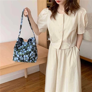 Floral canvas shoulder bag featuring blue five-petal flower jacquard on a black base
