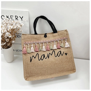 Detail of jute tote bag showing Mama print, colorful tassels and woven handle texture