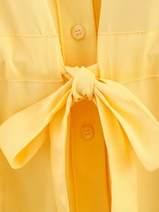 Close-up of yellow twill fabric detailing the bow tie and matching buttons on the shirt