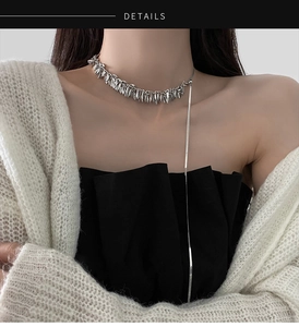 Macro detail of silver wheat sequin necklace with long tassel pendant on model