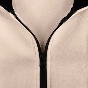 Detailed macro view of high-quality zipper and knit texture on men's beige fleece hoodie