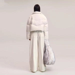 Rear view of white cropped down jacket paired with wide-leg pants and faux fur tote bag