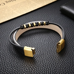 Detail of men's leather bracelet with magnetic clasp on vintage paper and leather background