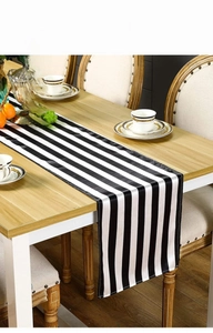 Detail view of modern black and white striped table runner with elegant polyester texture