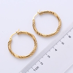Golden 30mm twisted hoop earrings in polished metal finish shown with a metric ruler