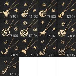 Flat lay of 13 gold-toned jewelry sets with diverse motifs on a dark textured background