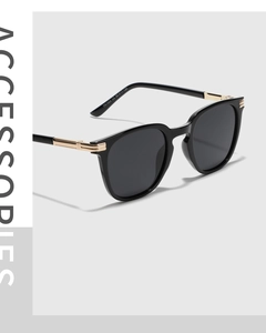 Detail of square TR90 sunglasses with gold metal trim on the glossy black temples