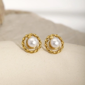 Detailed macro shot of vintage gold twisted metal earrings with white round pearls