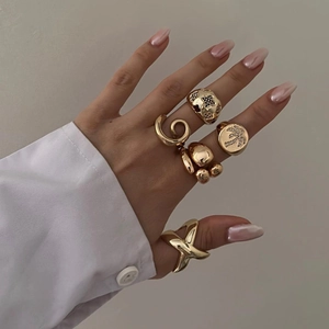 Detailed view of layered 18k gold plated stainless steel rings worn on model fingers
