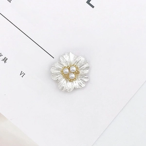 Dettaglio accessorio in lega a forma di foglia con tre perle bianche e petali metallici