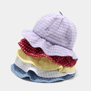 Una pila di cappelli alla pescatora a quadretti colorati con tesa ondulata estiva