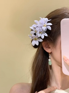 Détail d'une épingle à cheveux fleur en tissu lavande et boucles d'oreilles en jade