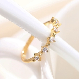 Vista macro de anillo de oro 18K con circonitas blancas engastadas en diseño de onda