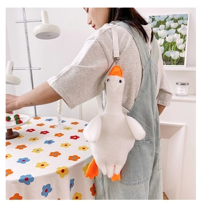 Close-up of white plush goose crossbody bag with orange beak and adjustable strap