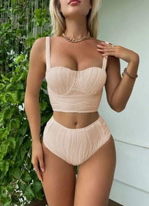 Detail of beige two-piece swimsuit featuring textured wave fabric and high-waisted bikini cut