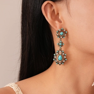 Close-up of vintage flower earrings with turquoise and pearls on model side view