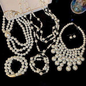 Detail view of elegant pearl necklace and bracelet set on reflective surface