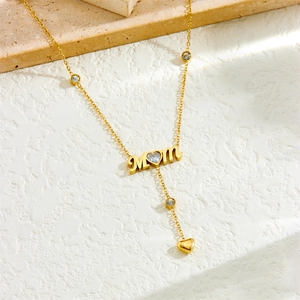 Collier MOM doré avec pierre précieuse en cœur et accents de cristal sur fond beige