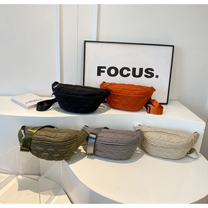 Five quilted crossbody bags in black, orange, green, grey, and beige on display