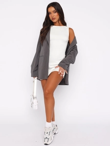 Blazer gris foncé associé à une robe moulante blanche sans manches pour l'été