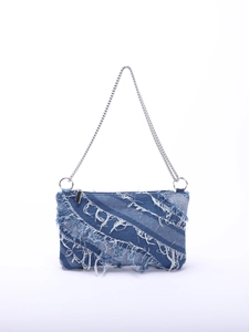 Close-up of blue denim shoulder bag with frayed fringe edges and silver chain strap