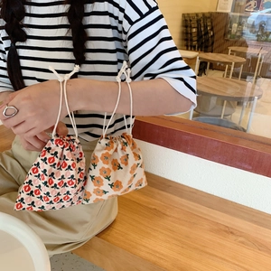 Detail view of corduroy drawstring pouches with floral patterns and white cotton ropes