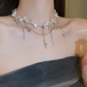 Détail du collier de perles irrégulières avec breloques étoile et croix en argent