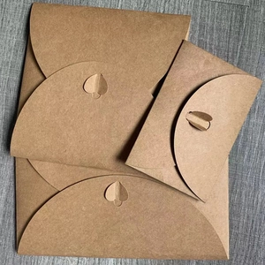 Detailed view of brown kraft paper envelopes with creative heart-shaped clasp closure