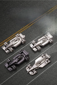 Set of four F1 race car keychains in silver and gun black on a realistic track background