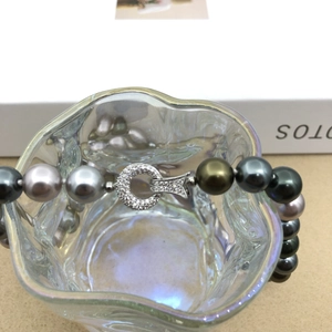 Detail of Tahitian style multi-color pearl necklace with a shimmering silver diamond clasp