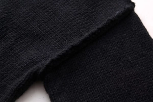 Close-up of black knit fabric texture showing heavy-duty seams and knit patterns