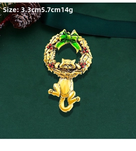 Detail of Christmas cat wreath brooch with green bow and red berries on a dark background