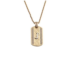Détail macro du pendentif rectangulaire doré avec lettre J et pierres de zircone pavées