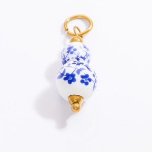 Pendentif gourde en porcelaine bleue et blanche avec détails dorés et motifs floraux