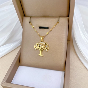 Elegant gold tree of life necklace with clear crystals in a beige jewelry gift box