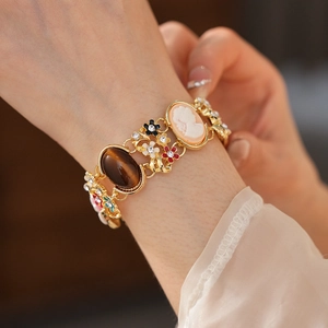 Detail of vintage enamel bracelet featuring flower motifs and a girl cameo portrait