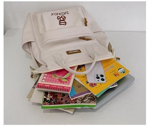 Top view of cream white backpack with wide opening showing large interior for books