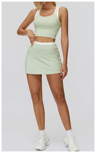 Detailed close-up of light green tennis set with layered sports bra and high-waisted skirt