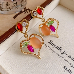Detail of vintage heart earrings with colorful rhinestones and hammered gold finish