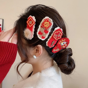 Close-up of red festive hair clips with embroidery and pearls in a New Year set