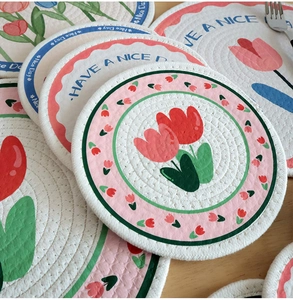 Dettaglio di tovagliette in cotone intrecciato con stampe tulipani e scritta Have a Nice Day