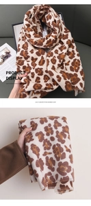 Detail of leopard print cashmere feel scarf with soft fringed edges and warm texture