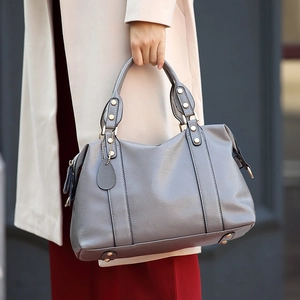 Silver-grey lychee texture Boston handbag with double handles shown in a city setting