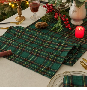 Detail of green and red plaid table runner made of thick linen for Christmas dining decor