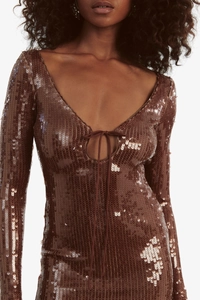 Detail of sequin long sleeve dress with deep V-neckline and tie detail in brown