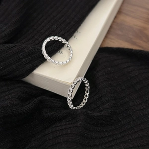 Minimalist 925 sterling silver heart rings set displayed on a white book and knit fabric
