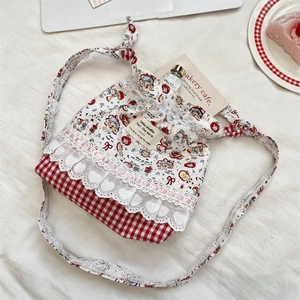 Détail du sac seau à carreaux rouge et blanc avec bordure en dentelle et motif dessin