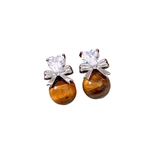 Vintage tiger eye earrings with silver bow and heart zircon drop on white background
