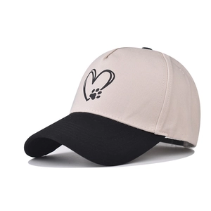 Two-tone cotton baseball cap in beige and black with minimalist heart and paw print
