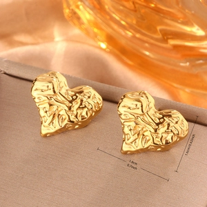 Dettaglio ravvicinato di orecchini a cuore placcati oro 18K con texture metallica stropicciata